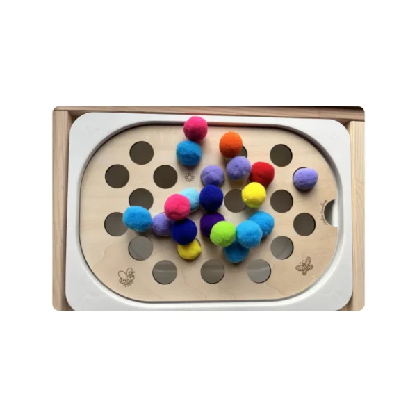 Insert sensoriel en bois gros trous pompons - avec gros pompons colorés posés dessus